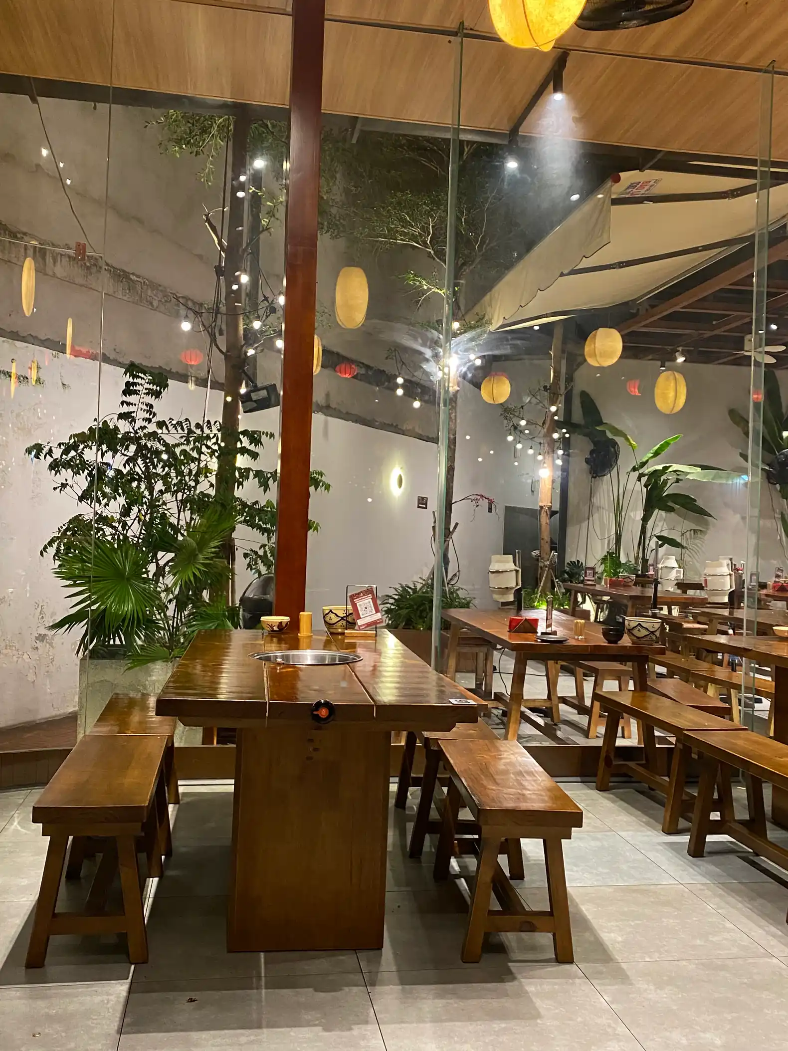 Không gian bàn gỗ và cây xanh tại Ram Nướng Phan Thiết